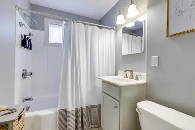 a white bathroom with a sink and a shower at 3 Mi to Dtwn Springfield Winter Retreat with Office in Springfield