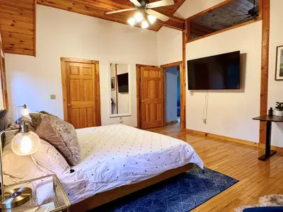 a bedroom with a bed and a flat screen tv at Spring skiing with friends & family - Berkshires in Otis