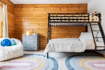 a bedroom with a bunk bed and a wooden wall at Spring skiing with friends & family - Berkshires in Otis