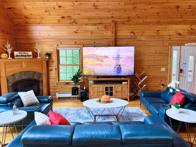 a living room with blue couches and a large screen at Spring skiing with friends & family - Berkshires in Otis