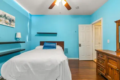 a blue bedroom with a bed and a ceiling fan at Cozy Retreat, Steps to Yale Bridgeport Hospital in Bridgeport