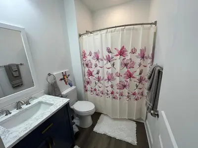 a bathroom with a toilet and a shower curtain at NEW 3 bedroom - Thoroughbred Farm & Lake Views! in Saratoga Springs