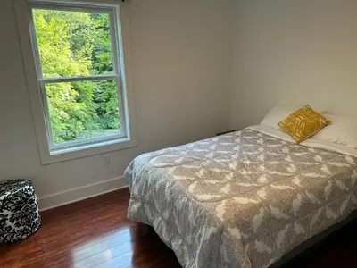 a bedroom with a bed and a window at NEW 3 bedroom - Thoroughbred Farm & Lake Views! in Saratoga Springs
