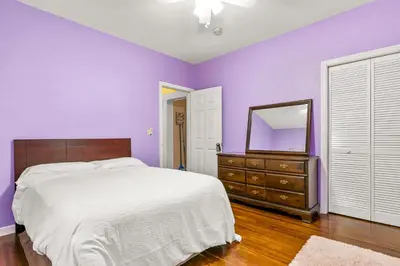a bedroom with purple walls and a bed and a mirror at Bridgeport Bliss Solo Haven Near Yale & Downtown in Bridgeport