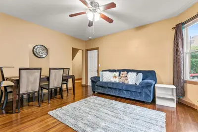 a living room with a blue couch and a table at Bridgeport Bliss Solo Haven Near Yale & Downtown in Bridgeport