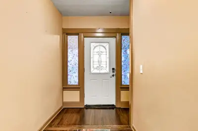 an empty hallway with a white door and windows at Bridgeport Bliss Solo Haven Near Yale & Downtown in Bridgeport