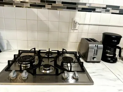 a stove top in a kitchen next to a microwave at 3-A Diamond in Yonkers, NY in Yonkers