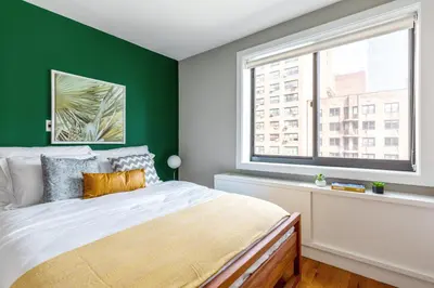 a bedroom with green walls and a bed with a window at Chelsea 1BR w Balcony Doorman Gym NYC-135 in New York