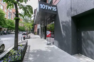 a building with a sign on it on a street at Chelsea 1BR w Balcony Doorman Gym NYC-135 in New York