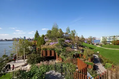 a garden with flowers and a fence next to the water at Chelsea 1BR w Balcony Doorman Gym NYC-135 in New York