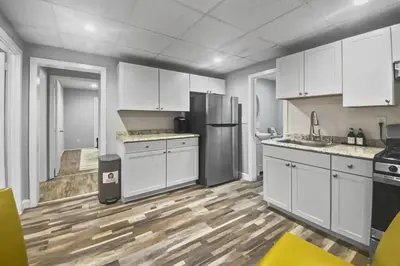 a kitchen with white cabinets and a wooden floor at Stylish & Cozy Perfect Hub for Stamford Escapades in Stamford