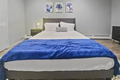 a large bed with a blue blanket on top of it at Stylish & Cozy Perfect Hub for Stamford Escapades in Stamford