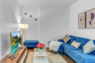a living room with a blue couch and a tv at 2Bd Stylish Brooklyn Heights - Steps WaterFront in Brooklyn