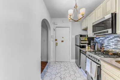 a kitchen with white cabinets and a stove top oven at 2Bd Stylish Brooklyn Heights - Steps WaterFront in Brooklyn