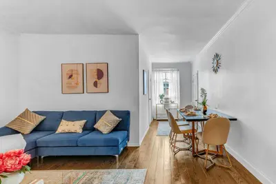a living room with a blue couch and a table at 2Bd Stylish Brooklyn Heights - Steps WaterFront in Brooklyn