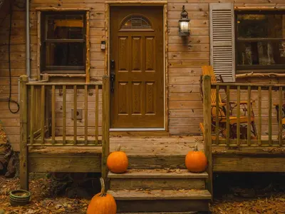 a house with pumpkins sitting on the front porch at Enchanting River- Water Front A-Frame Cabin in Yulan