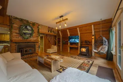 a living room with a couch and a fireplace at Enchanting River- Water Front A-Frame Cabin in Yulan