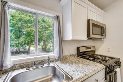 a kitchen with a sink and a stove and a window at Cozy Glens Falls Getaway Less Than 1 Mi to Downtown in Glens Falls