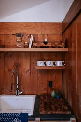 a kitchen with a sink and wooden walls at The Leeway in Mount Tremper