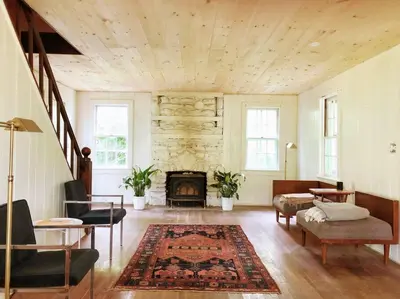 a living room with a fireplace and a table and chairs at Mountain Farmhouse (The Lorca, Catskills) in Shandaken