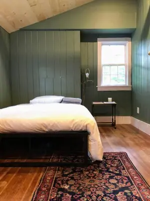 a bedroom with a bed with a rug and a window at Mountain Farmhouse (The Lorca, Catskills) in Shandaken