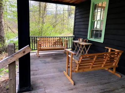 a porch of a house with two benches on it at Mountain Farmhouse (The Lorca, Catskills) in Shandaken