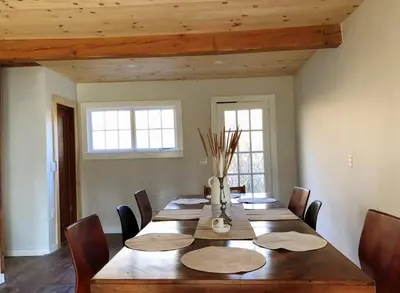 a dining room with a wooden table and chairs at Mountain Farmhouse (The Lorca, Catskills) in Shandaken