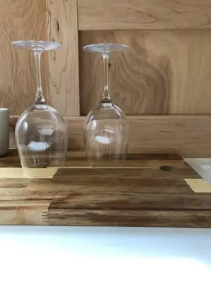 two wine glasses sitting on top of a wooden table at Modern Cottage One (The Lorca, Catskills) in Shandaken