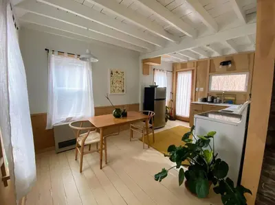 a living room with a table and a kitchen at Modern Cottage One (The Lorca, Catskills) in Shandaken