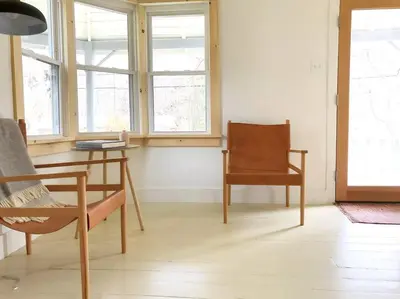 a room with a chair and a table and windows at Modern Cottage One (The Lorca, Catskills) in Shandaken
