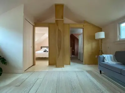 a living room with a blue couch and a bedroom at Modern Cottage One (The Lorca, Catskills) in Shandaken