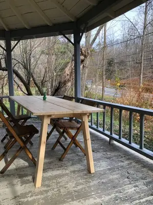 a wooden picnic table and a bench on a porch at Modern Cottage One (The Lorca, Catskills) in Shandaken
