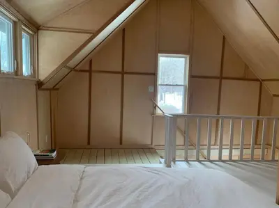 a room with a bed and a window and a staircase at Modern Cottage Two (The Lorca, Catskills) in Shandaken