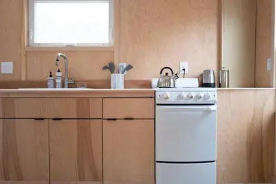 a kitchen with a white stove and a sink at Modern Cottage Two (The Lorca, Catskills) in Shandaken
