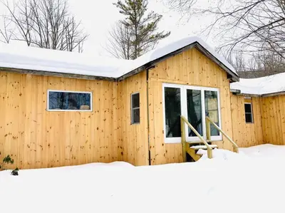 a wooden house with snow on the roof at Stream House (The Lorca, Catskills) in Shandaken