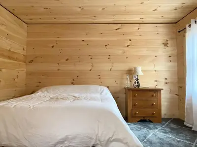 a bedroom with a bed and a wooden wall at Stream House (The Lorca, Catskills) in Shandaken