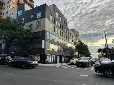 a building on a city street with cars parked in front at Regal Inn & Suites New York LaGuardia Hotel in Flushing