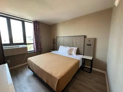 a bedroom with a large bed and a window at Regal Inn & Suites New York LaGuardia Hotel in Flushing