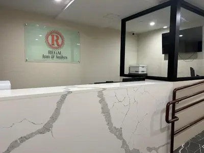 a bathroom with a marble counter with a mirror at Regal Inn & Suites New York LaGuardia Hotel in Flushing
