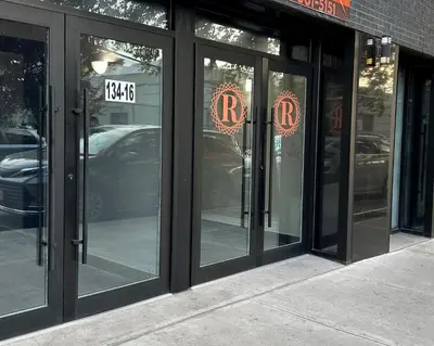 a store front with glass doors with the rtk sign on it at Regal Inn & Suites New York LaGuardia Hotel in Flushing