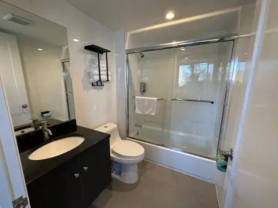 a bathroom with a shower and a toilet and a sink at Regal Inn & Suites New York LaGuardia Hotel in Flushing