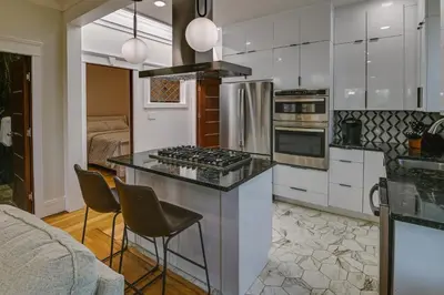 a kitchen with a island with a stove top oven at Contemporary Cohoes Retreat with Electric Fireplace! in Cohoes