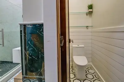 a bathroom with a toilet and a glass door at Contemporary Cohoes Retreat with Electric Fireplace! in Cohoes