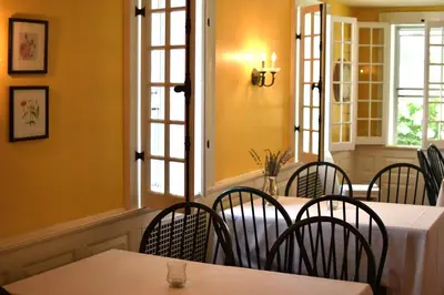 a dining room with tables and chairs and windows at The Inn at Richmond in Richmond