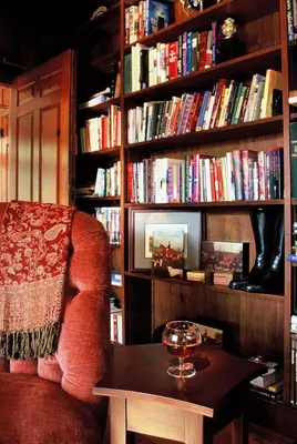 a library with a chair and a table with a wine glass at The Inn at Richmond in Richmond