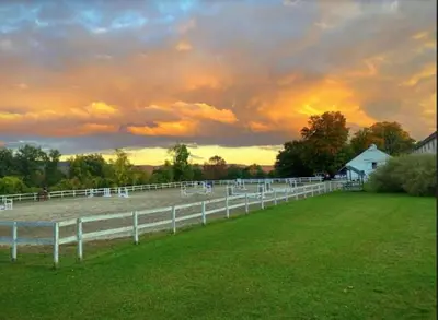 a white fence in a field with a sunset at The Inn at Richmond in Richmond