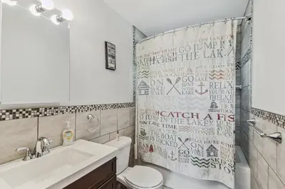 a bathroom with a sink toilet and a shower curtain at Poconos Chalet newly renovated, great location home in Tobyhanna