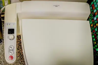 a white printer sitting on a counter with a remote control at GABLES new 2024 in Bayside