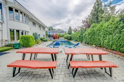 a picnic table and two chairs in front of a pool at GABLES new 2024 in Bayside