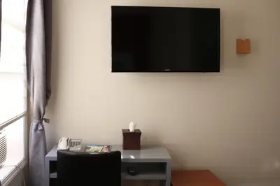 a room with a desk and a television on the wall at Midtown West Hotel in New York